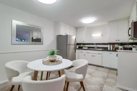 a kitchen with stainless steel appliances granite countertop a dining table and chair