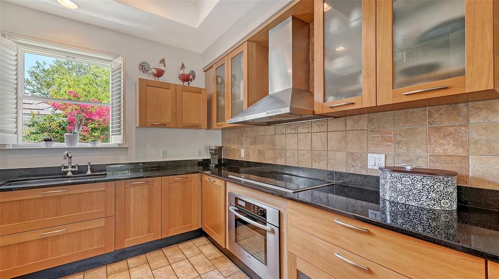 33 Bishopscourt Road, Unit 118 Osprey, FL 34229 - Photo 23 of 80 a kitchen with granite countertop a sink and a stove