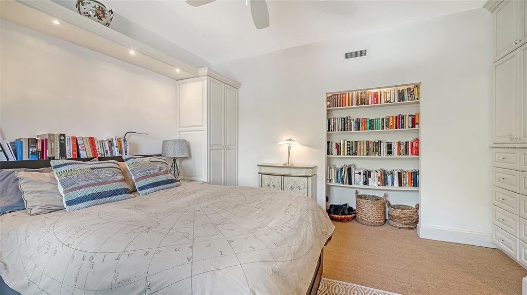 33 Bishopscourt Road, Unit 118 Osprey, FL 34229 - Photo 36 of 80 a bedroom with a bed furniture and a book shelf