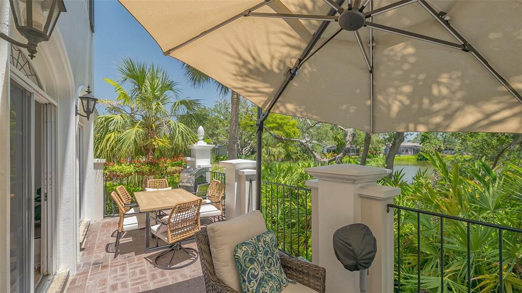 33 Bishopscourt Road, Unit 118 Osprey, FL 34229 - Photo 39 of 80 a view of a porch with chairs and potted plants