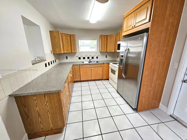 a kitchen with stainless steel appliances granite countertop a refrigerator a sink a stove a microwave and island