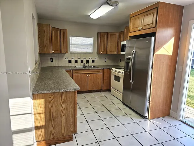 a kitchen with stainless steel appliances granite countertop a refrigerator sink and cabinets