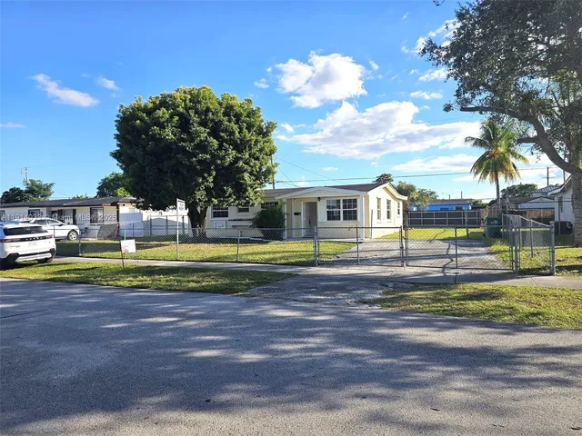 a view of swimming pool with outdoor seating and house in the background