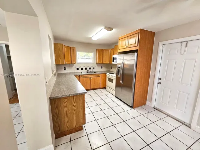 a kitchen with stainless steel appliances granite countertop a refrigerator and a stove