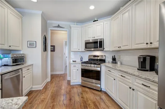 a kitchen with granite countertop a sink cabinets and stainless steel appliances