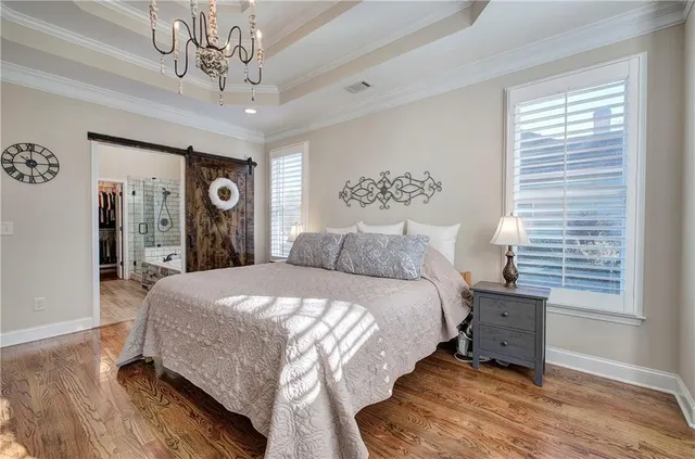 a spacious bedroom with a bed and a chandelier