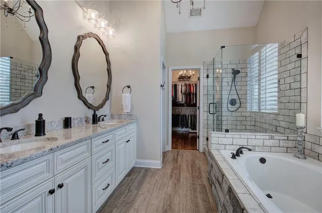 a spacious bathroom with a granite countertop sink mirror and bathtub