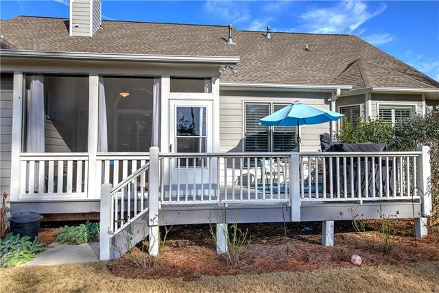a view of a house with wooden deck and furniture