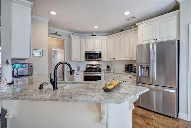 a kitchen with a refrigerator sink and white cabinets