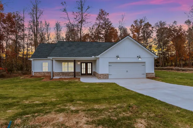 a view of a house with a yard and tree s