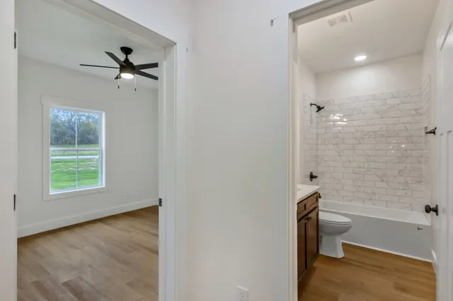 a bathroom with a granite countertop toilet a sink and shower