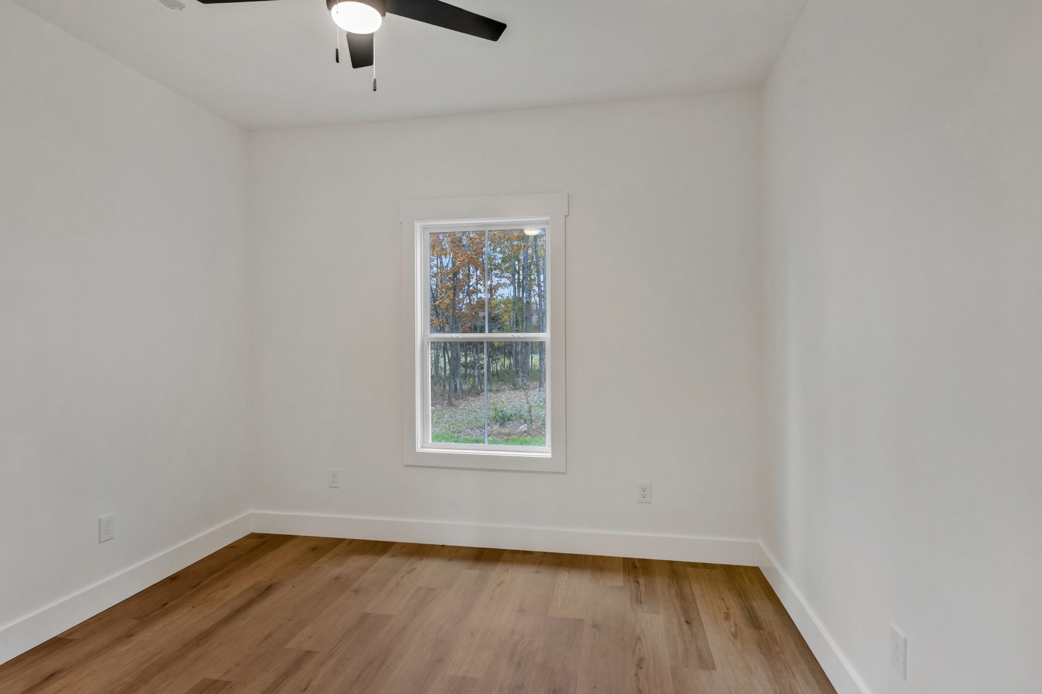482 Boswell Road Winchester, TN 37398 - Photo 28 of 36 an empty room with wooden floor chandelier fan and windows