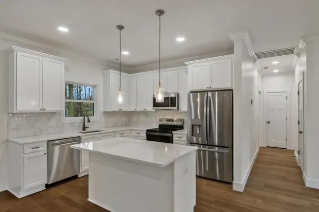 a kitchen with a refrigerator a sink and cabinets