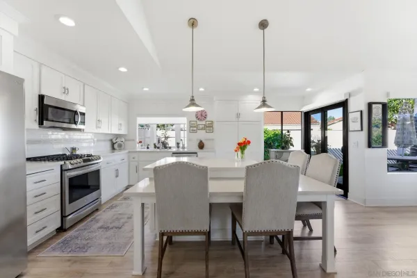 a view of kitchen with stainless steel appliances granite countertop a stove a sink a dining table and chairs