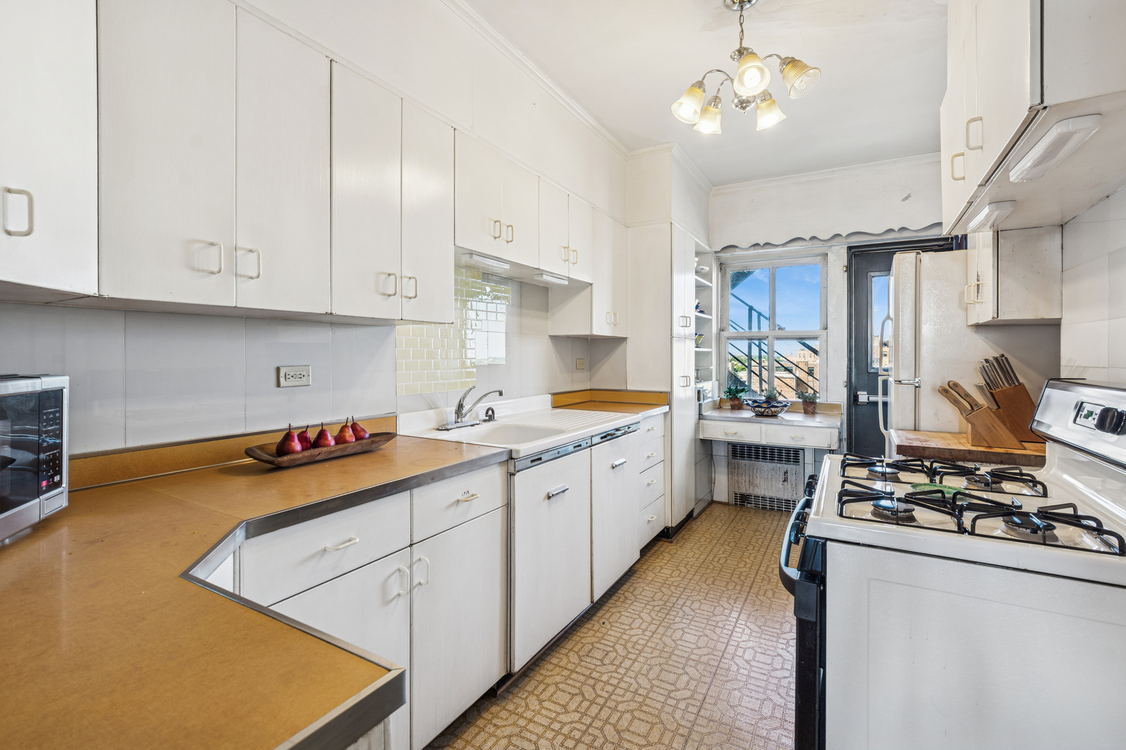 5000 North Marine Drive, Unit 9C Chicago, IL 60640 - Photo 14 of 20 a kitchen with stainless steel appliances granite countertop a stove a sink dishwasher and white cabinets with wooden floor