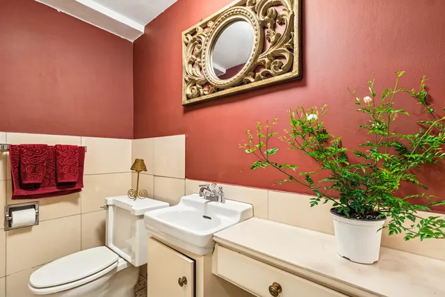 a bathroom with a toilet sink and mirror