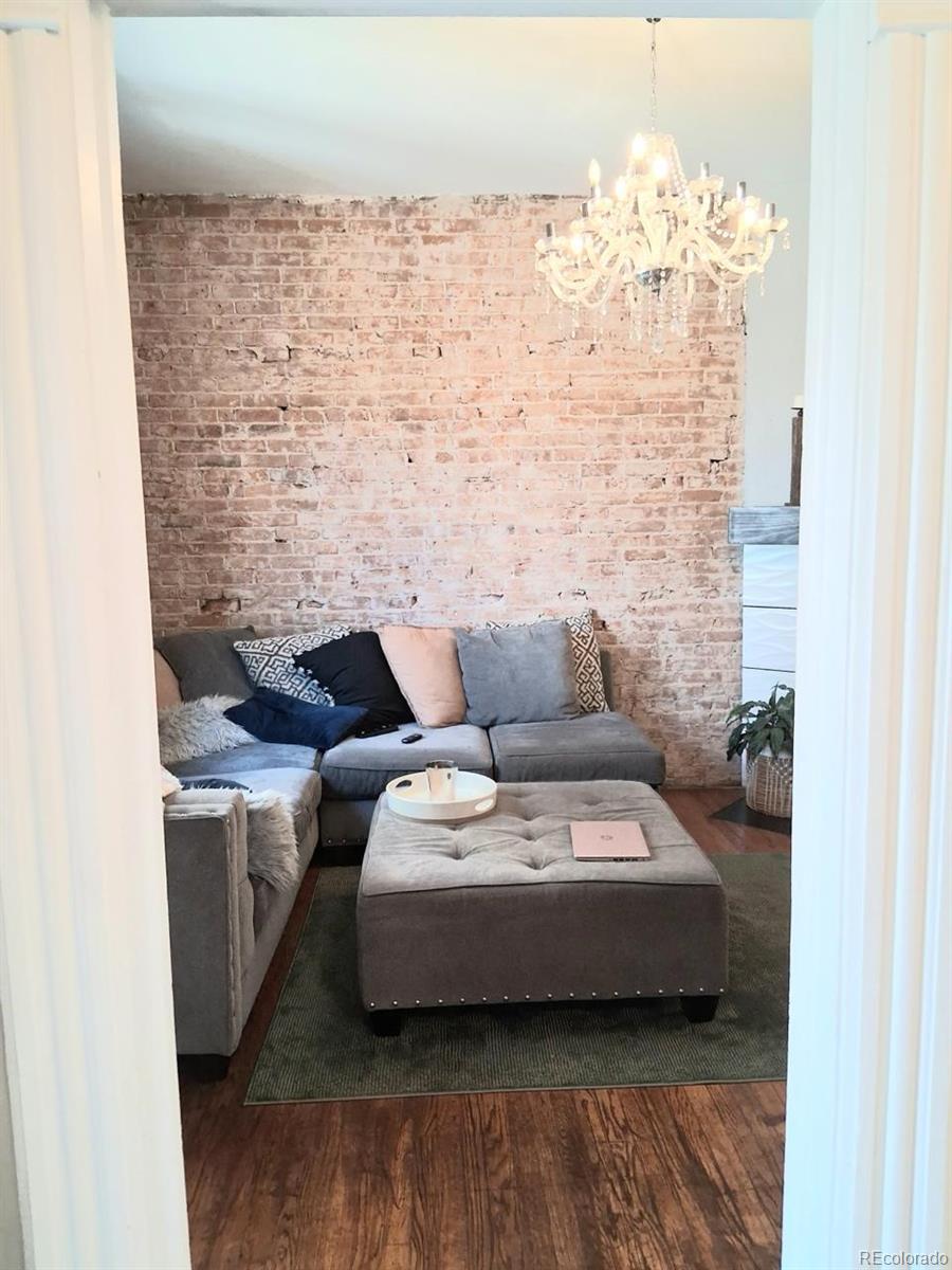 451 Acoma Street Denver, CO 80204 - Photo 9 of 19 a living room with furniture and a chandelier