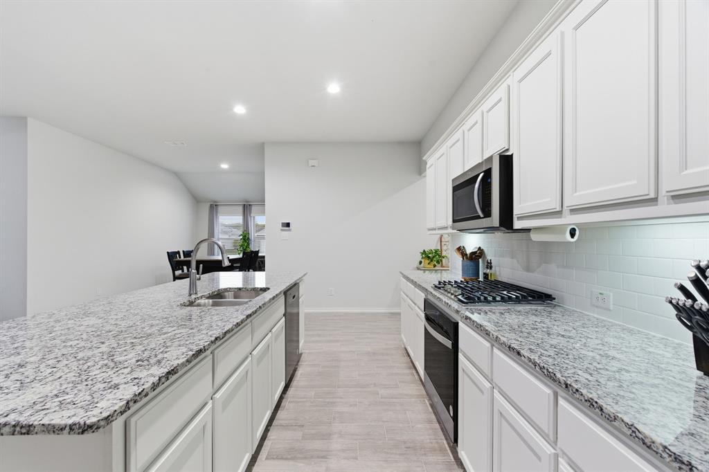 437 Falcon Way Azle, TX 76020 - Photo 13 of 40 a kitchen with stainless steel appliances granite countertop a stove and a sink