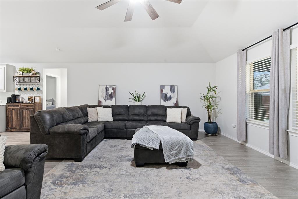 437 Falcon Way Azle, TX 76020 - Photo 7 of 40 a spacious bedroom with a bed a couch and a chandelier