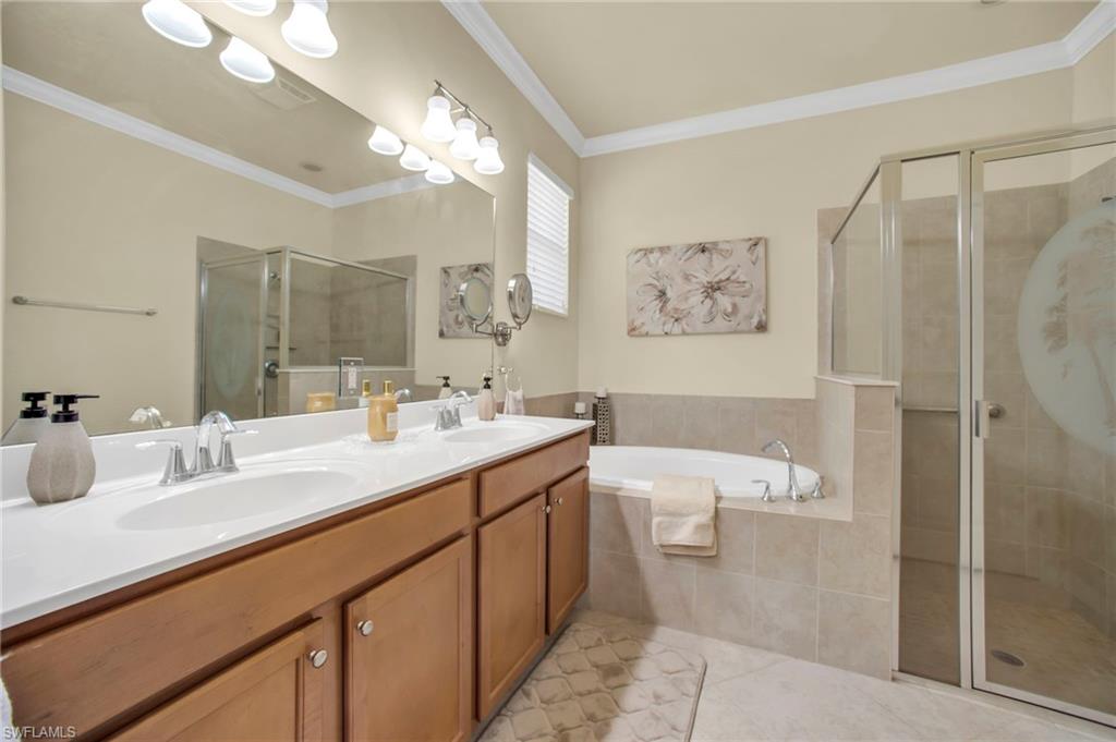 14513 Lanier Court Naples, FL 34114 - Photo 15 of 42 Bathroom featuring crown molding, a soaking tub, separate shower stall, double vanity