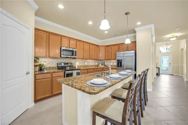 a kitchen with granite countertop kitchen island a counter top space a sink stainless steel appliances and cabinets