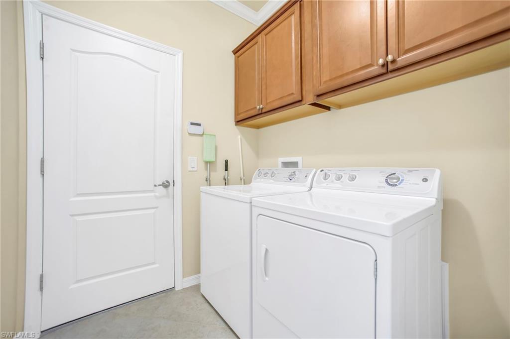 14513 Lanier Court Naples, FL 34114 - Photo 25 of 42 Laundry room featuring cabinet space, washer and dryer, and crown molding