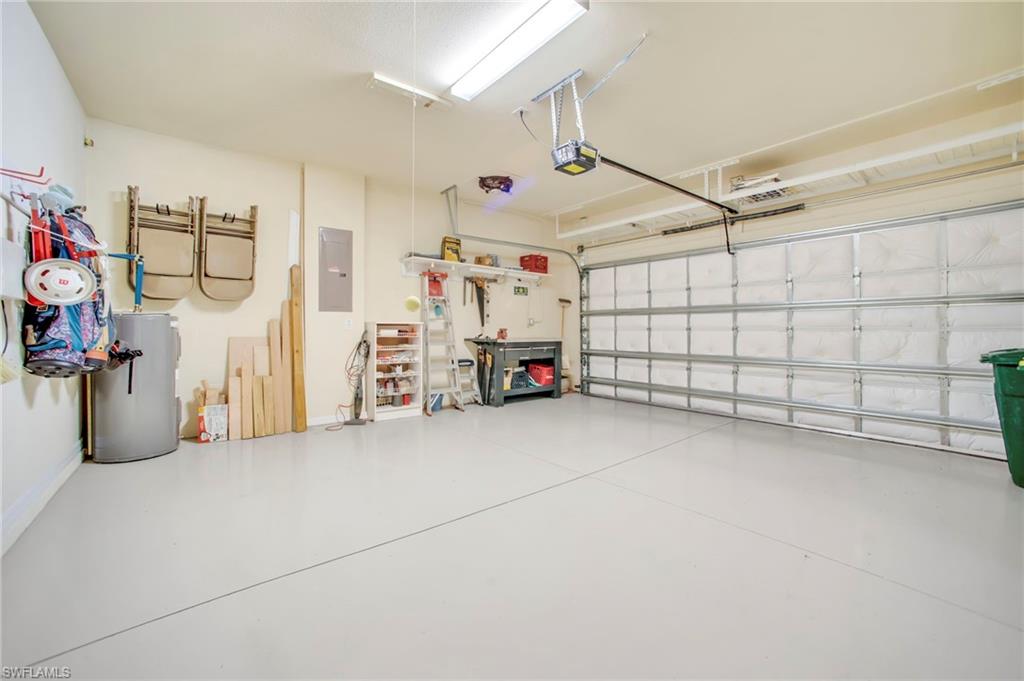 14513 Lanier Court Naples, FL 34114 - Photo 26 of 42 Garage with water heater, electric panel, work bench, loft storage and attic storage
