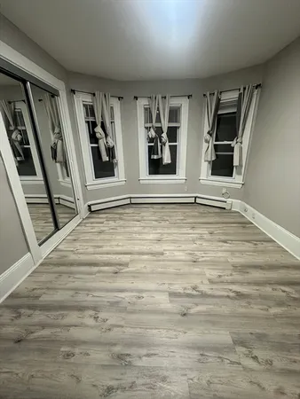 a view of an empty room with window and stairs