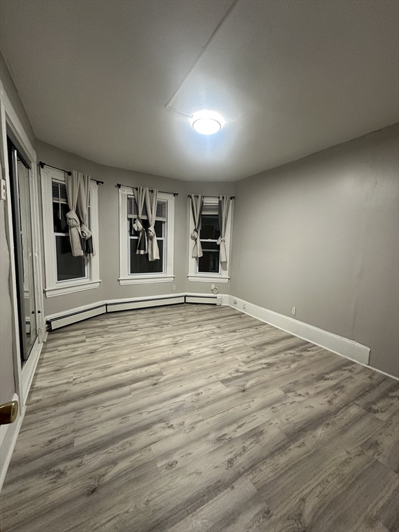 269 South Broadway, Unit 2 Lawrence, MA 01843 - Photo 5 of 12 a view of an empty room with a window and wooden floor