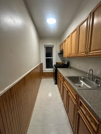 a kitchen with granite countertop a sink stove and cabinets