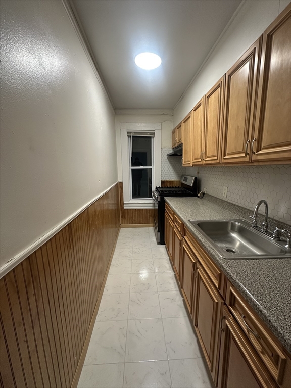 269 South Broadway, Unit 2 Lawrence, MA 01843 - Photo 8 of 12 a kitchen with granite countertop a sink stove and cabinets