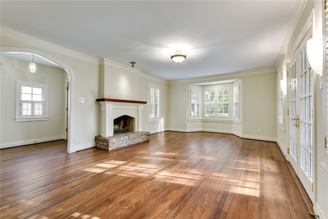 an empty room with windows and fireplace