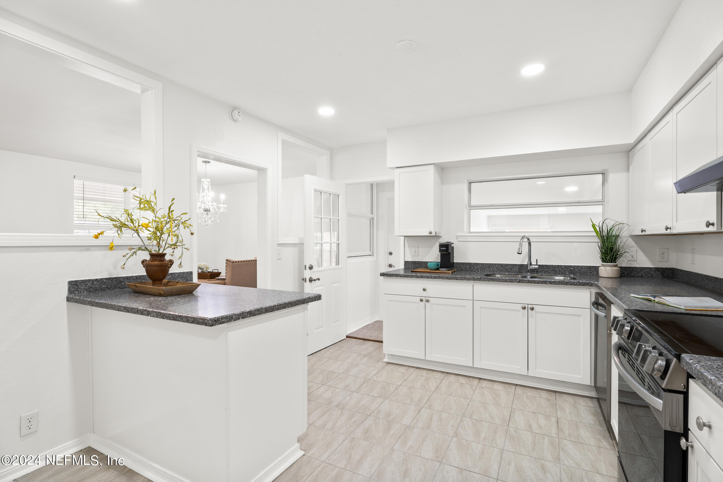 755 Old Hickory Road Jacksonville, FL 32207 - Photo 15 of 30 a kitchen with stainless steel appliances granite countertop a sink stove and white cabinets with wooden floor
