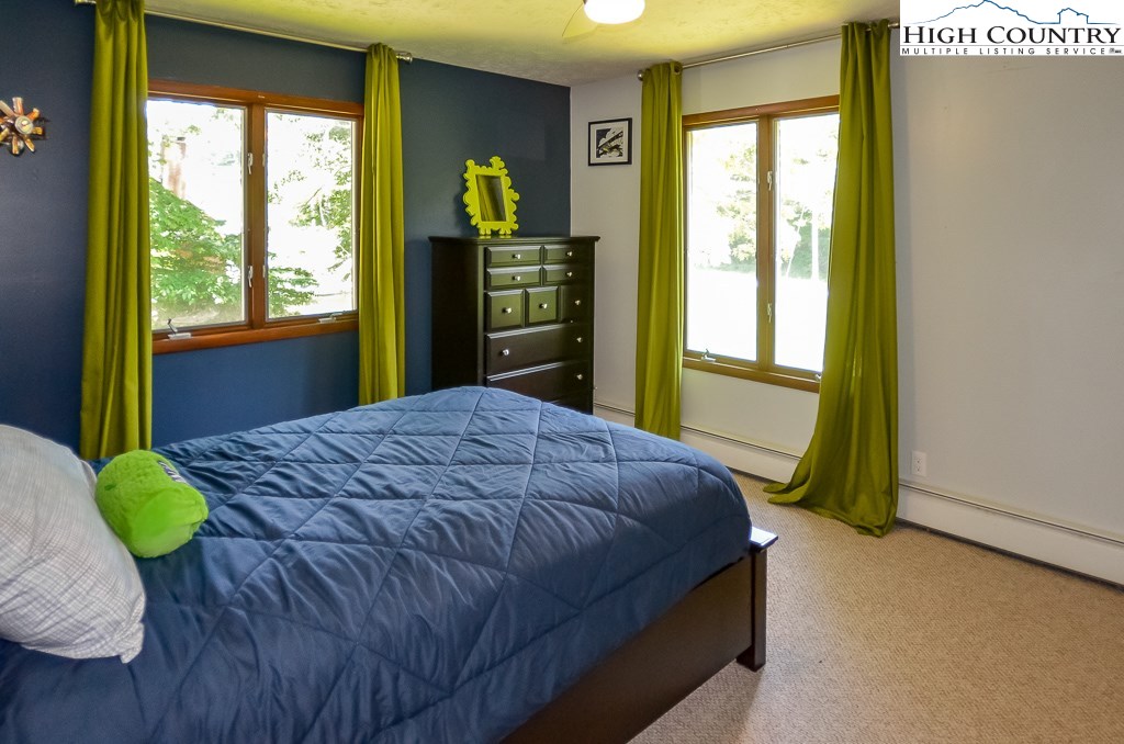 165 Wilson Ridge Road Boone, NC 28607 - Photo 13 of 22 a bedroom with a bed and large windows