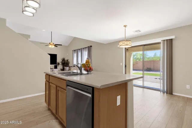 a kitchen with stainless steel appliances granite countertop a sink a stove and a wooden floor