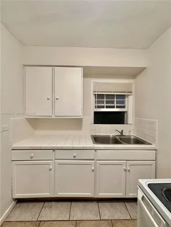 a kitchen with white cabinets and white appliances