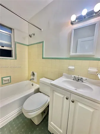 a bathroom with a sink a toilet a mirror and bathtub