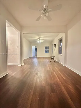 a view of a room with wooden floor and ceiling fan