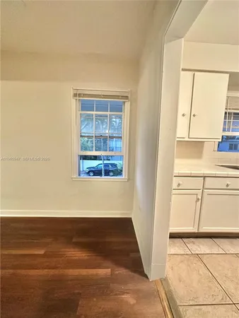 a view of a kitchen with wooden floor and cabinets