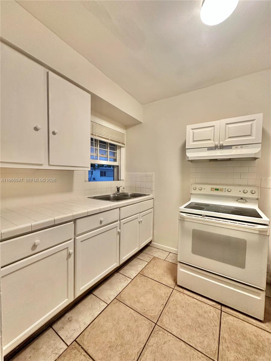 430 76th Street, Unit 4 Miami Beach, FL 33141 - Photo 8 of 24 a kitchen with cabinets and appliances