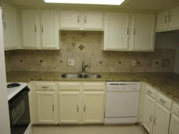a kitchen with white cabinets appliances and sink