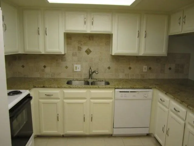 a kitchen with white cabinets appliances and sink