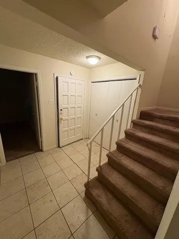 a view of entryway with stairs and a rug