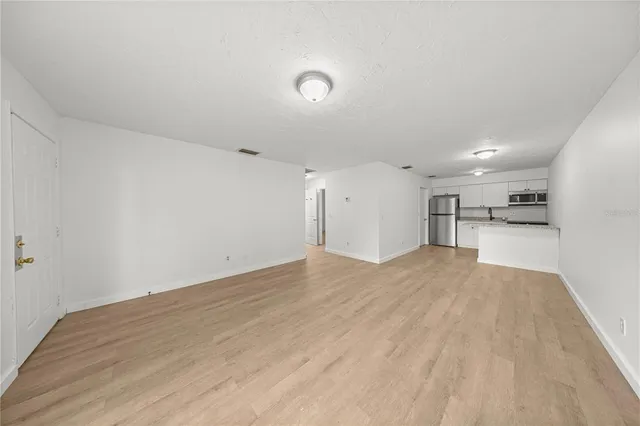 an empty room with a window and a ceiling fan
