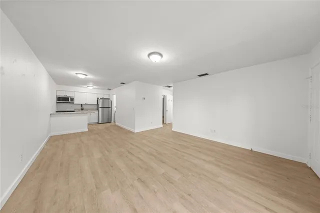 a kitchen with a refrigerator a stove top oven and white cabinets