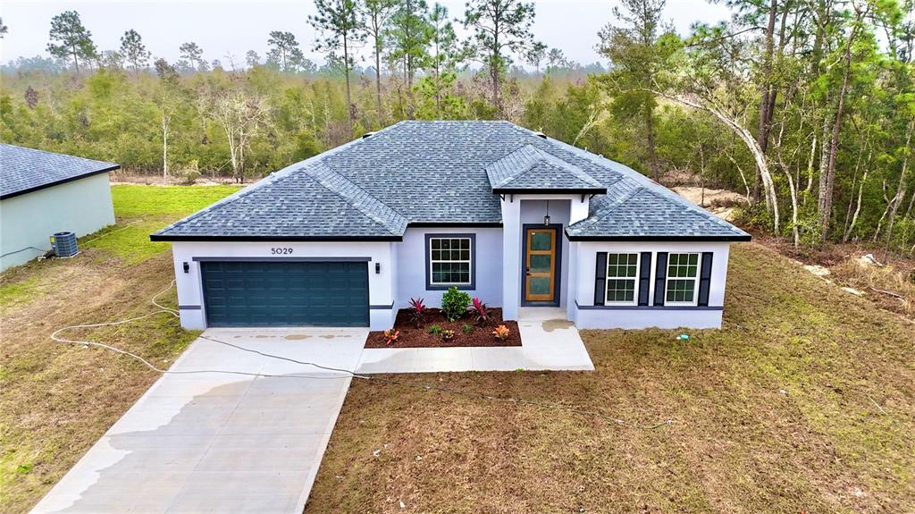 5029 Southwest 150th Lane Road Ocala, FL 34473 - Photo 1 of 1 a front view of a house with yard patio and garage