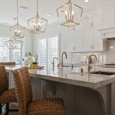a kitchen with stainless steel appliances granite countertop a sink a stove a dining table and chairs
