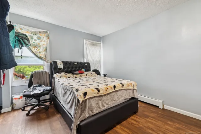 a bedroom with a bed wooden floor and window