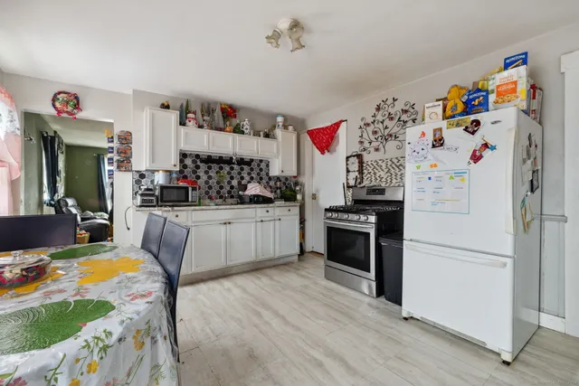 a kitchen with a refrigerator and a stove top oven