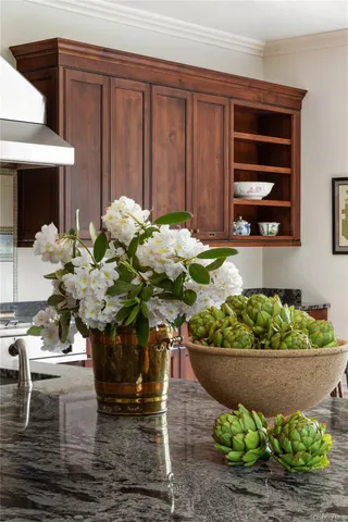 a vase of flowers sitting on a table in front of a house